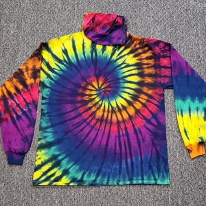 Peut inclure: Un t-shirt &agrave; manches longues avec un motif tie-dye dans des tons de bleu, jaune, orange, rouge et violet. Le t-shirt a un col montant.