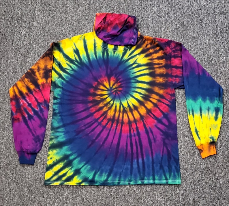 Peut inclure: Un t-shirt &agrave; manches longues avec un motif tie-dye dans des tons de bleu, jaune, orange, rouge et violet. Le t-shirt a un col montant.