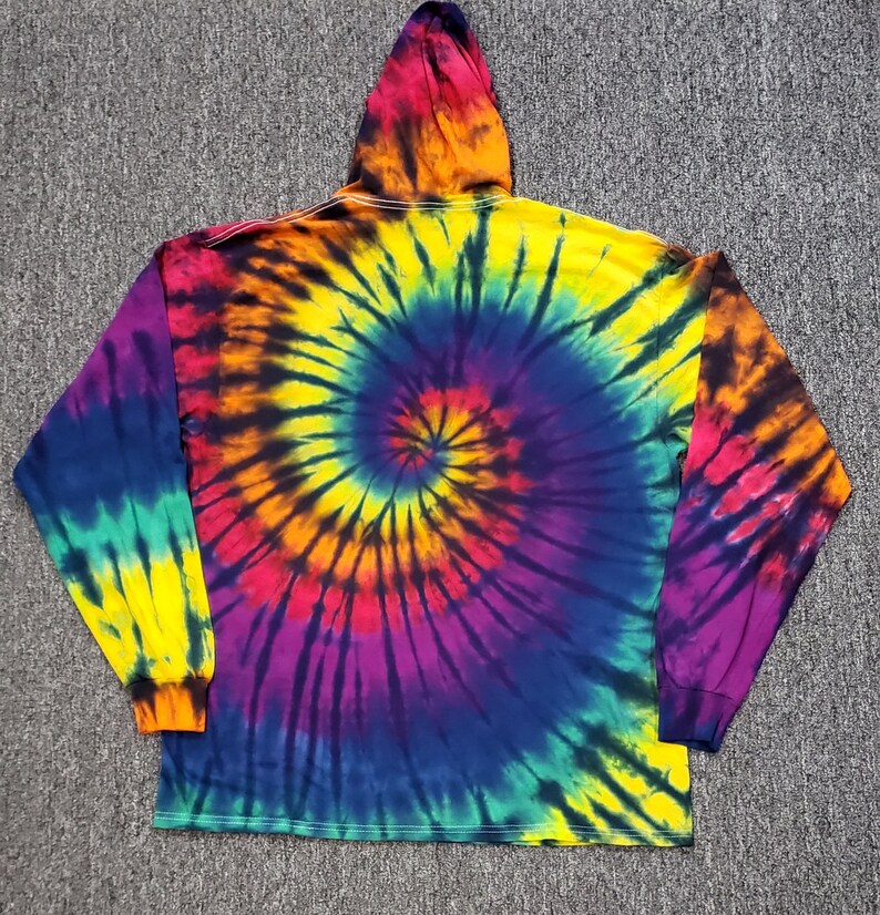 Peut inclure: Un sweat &agrave; capuche tie-dye &agrave; manches longues avec un motif tourbillonnant de jaune, orange, rouge, violet, bleu et vert.