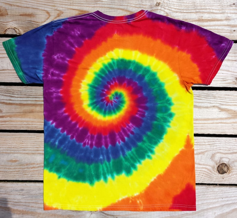 May include: A colorful tie-dye t-shirt with a spiral pattern. The shirt features a vibrant blend of rainbow colors, including red, orange, yellow, green, blue, and purple. The shirt is made of soft material and has a classic crew neck.