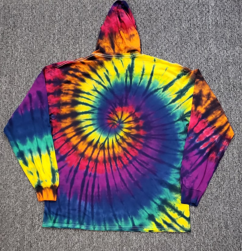 Peut inclure: Un sweat &agrave; capuche tie-dye &agrave; manches longues avec un motif tourbillonnant de jaune, orange, rouge, violet, bleu et vert.