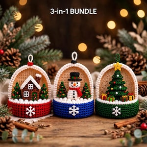 May include: A 3-in-1 BUNDLE of three crocheted dome ornaments. The first features a brown house with a white roof, the second a snowman with a black hat and red scarf, and the third a green Christmas tree with gifts, all with white snowflakes.