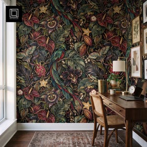 Könnte beinhalten: Tapete mit dunklem botanischem Muster aus tropischen Blumen, großen grünen Blättern, einem Quetzal, Motten und sternförmigen Früchten. Ein Schreibtisch aus Holz mit Rohrgeflechtstuhl, Lampe, Büchern und Laptop steht vor der Wand.
