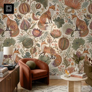 Könnte beinhalten: Tapete mit einem sich wiederholenden Muster aus Füchsen und stilisierten botanischen Elementen in Orange-, Grün- und Violetttönen auf cremefarbenem Grund. Das Design umfasst komplexe florale Motive, große runde Samenkapseln und Blattwerk.