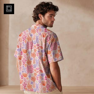 Könnte beinhalten: Kurzärmeliges Hemd mit einem farbenfrohen Blumenmuster in Rosa-, Orange- und Lilatönen. Das Hemd hat einen klassischen Kragen und ist aus leichtem Stoff gefertigt. Ein modisches Kleidungsstück für den Sommer.