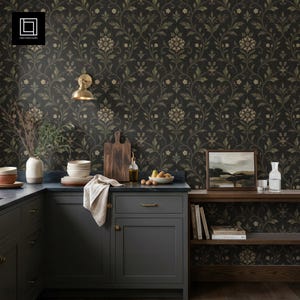 May include: A kitchen scene with dark gray cabinets, a blue countertop, and a floral wallpaper background. The scene includes a cutting board, bowls, a vase, and a painting. A brass wall sconce is mounted on the wall.
