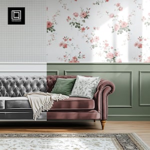 May include: A plush, burgundy velvet sofa with tufted upholstery and wooden legs. The sofa has two throw pillows, one green and one white with a floral pattern. A white throw blanket is draped over the sofa. The sofa is in front of a wall with a floral wallpaper pattern.