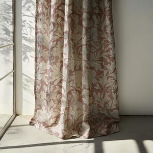 May include: A pair of pink and cream floral curtains with a flowing, draped design. The curtains are made of a lightweight fabric and have a subtle sheen.