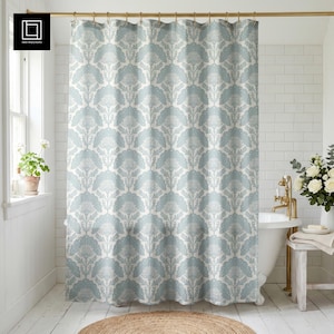 May include: A light blue and white floral patterned shower curtain hangs in a bathroom. The curtain is the focal point, with a repeating design of stylized flowers. The bathroom has white walls, a white bathtub, and a small rug on the floor.