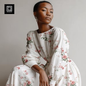 Peut inclure: Une robe blanche à imprimé floral avec des roses roses et des feuilles vertes. La robe a des manches longues et une encolure carrée. La modèle porte des créoles dorées. La robe est de longueur midi.