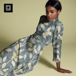 May include: A woman wearing a long-sleeved dress with a blue background and a white leaf pattern. The dress has a cinched waist and a flowing skirt.