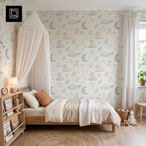 May include: A bedroom featuring wallpaper with a pattern of blue moons, clouds, stars, and green foliage. A wooden bed with beige bedding, a white canopy, and a wooden bookshelf containing books and a plush rabbit toy sits in the room.