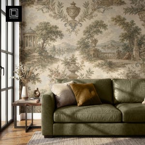 May include: A sage green leather sofa with two throw pillows, one beige and one mustard yellow, placed in front of a wall covered in wallpaper featuring a sepia-toned landscape scene with classical urns, trees, a gazebo, and figures.