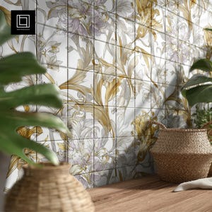 May include: Floral tile backsplash with a repeating pattern of stylized flowers in shades of gold, gray, and lavender against a white background. A woven basket and greenery are in the foreground, with a wooden surface.