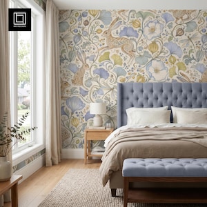 May include: Wallpaper featuring a repeating pattern of brown rabbits, blue and green ginkgo leaves, flowers, and dragonflies on a cream background. The design is displayed on a wall behind a tufted blue headboard, a bed with beige bedding, and a wooden nightstand.