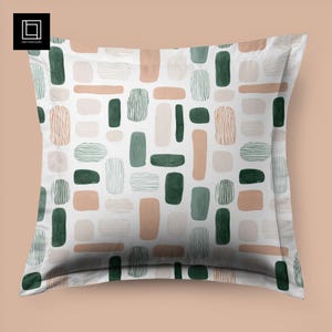 Peut inclure: Taie d'oreiller carrée blanche avec un motif répété de formes abstraites vertes, beiges et marron. Le motif comprend des rectangles, des ovales et des lignes, créant un design artistique moderne. La taie d'oreiller est de forme carrée.