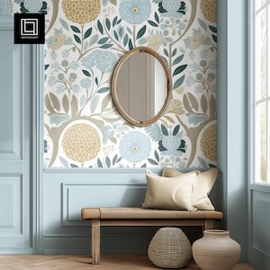 May include: A room with floral wallpaper in shades of blue, beige, and green. A gold oval mirror hangs on the wall above a wooden bench with cushions. A woven basket and a beige vase are on the floor.
