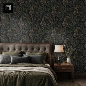 Puede incluir: Un dormitorio con papel pintado floral oscuro con patrones de helechos y hojas en tonos verdes y dorados. La cama tiene un cabecero acolchado, varias almohadas y ropa de cama verde oliva. Una mesita de noche de madera con lámpara y jarrón.