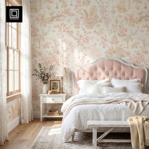 May include: A bedroom featuring a tufted light pink headboard, white bedding, and a white wooden nightstand. The walls are covered in wallpaper with a light pink and beige floral pattern, including pagodas and birds. A lamp sits on the nightstand.