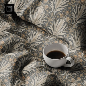May include: A white ceramic coffee cup filled with dark liquid rests on a patterned fabric. The fabric displays a repeating floral design in grey, beige, and brown tones. The image evokes a sense of comfort and sophistication.