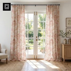 May include: A pair of floor-length curtains featuring a repeating toile pattern in muted pink and beige tones. The fabric displays intricate illustrations of pagodas, trees, and floral elements, hanging from a simple black metal curtain rod.