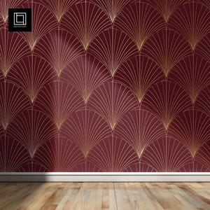 Puede incluir: Pared de color burdeos con un diseño de abanico art déco dorado. El diseño se repite por toda la pared. La pared está sobre un suelo de madera clara. La parte inferior de la pared tiene una moldura blanca.
