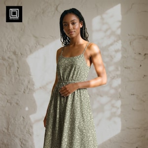 Könnte beinhalten: Ein salbeigrünes Midikleid mit einem zarten weißen Blumenmuster, dünnen Spaghettiträgern, einem Rundhalsausschnitt und einer gerafften, elastischen Taille. Das Kleidungsstück ist schlicht geschnitten und hat einen fließenden Rock.