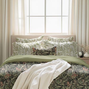 May include: A bed with a green and white floral patterned duvet cover and matching pillowcases. A white throw blanket is draped over the bed. The bed is made with a green and white floral patterned duvet cover and matching pillowcases. A white throw blanket is draped over the bed.