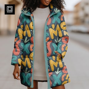 May include: A long, dark gray puffer coat with a colorful abstract pattern of yellow, orange, teal, and green shapes. The coat has a teal-colored trim and a hood. The model is wearing a white sweater underneath.