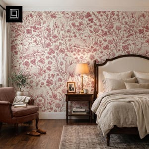 May include: Wallpaper featuring a repeating toile pattern in deep red on a cream background, depicting lambs amidst floral arrangements. The design covers a bedroom wall behind a wooden bed frame, a nightstand with a lamp, and an armchair.
