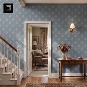 May include: A blue wallpaper with a repeating cream-colored damask pattern featuring small floral motifs. The wall is adorned with a wall-mounted light fixture, a wooden console table holding a flower vase, and a doorway leading to a room.