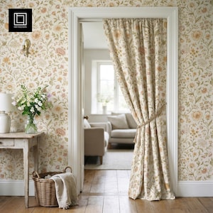 May include: A floor-length curtain featuring a floral pattern in muted shades of peach, green, and cream. The fabric is gathered and tied back with a simple rope cord, hanging within a white door frame against matching floral wallpaper.