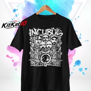 Könnte beinhalten: Ein schwarzes Kurzarm-T-Shirt mit einem weißen Grafikdruck der Band Incubus. Das Design zeigt Porträts der Bandmitglieder, florale Elemente sowie den Schriftzug "INCUBUS" oben und "BLACK HEART" am unteren Rand der Grafik.