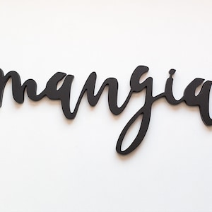 May include: Black wooden sign with the word "mangia" written in cursive.