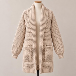 Könnte beinhalten: Eine beigefarbene Langarm-Strickjacke mit geripptem Schalkragen, zwei aufgesetzten Vordertaschen und gerippten Bündchen. Das Kleidungsstück ist in einem strukturierten Strickmuster gefertigt und zeigt durchgehend einen einheitlichen hellen Beigeton.