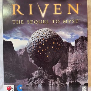 May include: A rectangular video game box for Riven: The Sequel to Myst. The cover features a large, textured, spherical tree structure with glowing yellow windows, set against a dark, rocky landscape under a cloudy sky. Logos for Red Orb and Cyan.