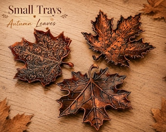 May include: Three leaf-shaped trays with a metallic copper finish. One tray features an intricate floral filigree pattern, while the other two display detailed embossed vein structures. The text "Small Trays Autumn Leaves" is visible at the top.