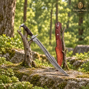 May include: A curved steel sword with a dark wooden handle and a metal crossguard, featuring a textured blade surface. Beside the sword stands a brown leather sheath with metal rivets and embossed line details, both resting on a mossy surface.