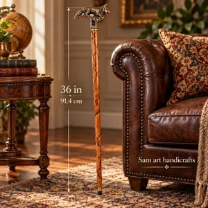 Könnte beinhalten: Ein Gehstock mit einem braunen, strukturierten Holzschaft und einem metallenen Griff in Wolfsform. Der Stock hat eine Gesamthöhe von 91,4 cm. Der Text Sam art handicrafts ist nahe dem Griff zu sehen. Die Stockspitze ist schwarz.