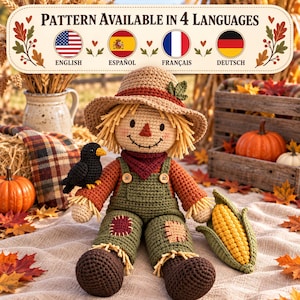 May include: A crocheted scarecrow doll wearing a tan hat, a rust-colored shirt, and olive green overalls with patches. The doll features a black crow on its shoulder and holds a yellow corn cob. Text above reads: Pattern Available in 4 Languages.