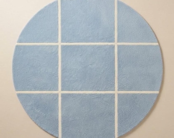 May include: A circular area rug featuring a light blue surface divided into a grid of nine equal squares by thin, intersecting white lines that form a cross pattern across the center of the round textile floor covering.