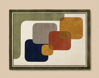 May include: A rectangular area rug featuring an off-white background with a dark olive green border. The design includes overlapping rounded squares in shades of navy blue, gray, mustard yellow, and terracotta orange, arranged in a diagonal pattern.