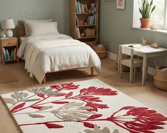 May include: A rectangular area rug featuring a cream-colored background with a large-scale botanical pattern of deep red and taupe-gray stylized flowers and leaves, covering the floor in a bedroom setting with a bed and wooden furniture.