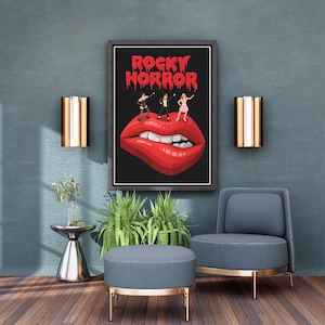 May include: A framed rectangular wall art print featuring the text ROCKY HORROR in a red dripping font above a graphic illustration of three small figures standing on a pair of large, glossy red lips with white teeth on a black background.