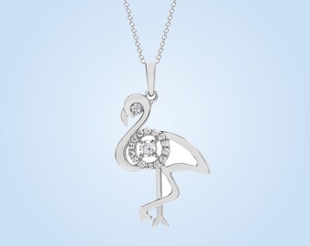 May include: A silver-toned necklace featuring a flamingo-shaped pendant. The flamingo design is accented with small, clear, round-cut stones embedded along the neck and a circular cluster of stones forming the center of the bird's body.