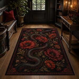 Puede incluir: Una alfombra rectangular con fondo negro que presenta un patrón de serpiente grande y sinuosa entrelazada con flores de amapola rojas vibrantes y follaje verde. El diseño cubre toda la superficie con un motivo botánico detallado.