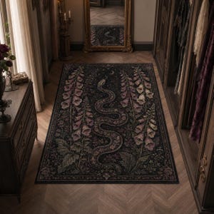 Può includere: Un tappeto rettangolare con sfondo scuro caratterizzato da un motivo centrale a serpente sinuoso, affiancato da alti steli di fiori di digitale rosa e viola. Il design include intricati dettagli botanici e una luna crescente in alto al centro.