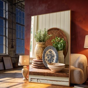 May include: A large rectangular floor mirror with a thin wooden frame reflecting a rustic wooden table holding a ceramic jug with rosemary, a blue and white floral patterned plate, a green basil plant, and a shallow beige ceramic bowl.