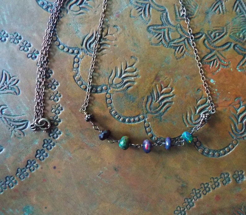 May include: A copper chain necklace with a delicate row of iridescent opal and black beads.