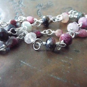 Pode incluir: Um bracelete de corrente de prata com pedras preciosas rosa, verde e preta. O bracelete &eacute; feito com contas envoltas em arame e elos de corrente de prata.